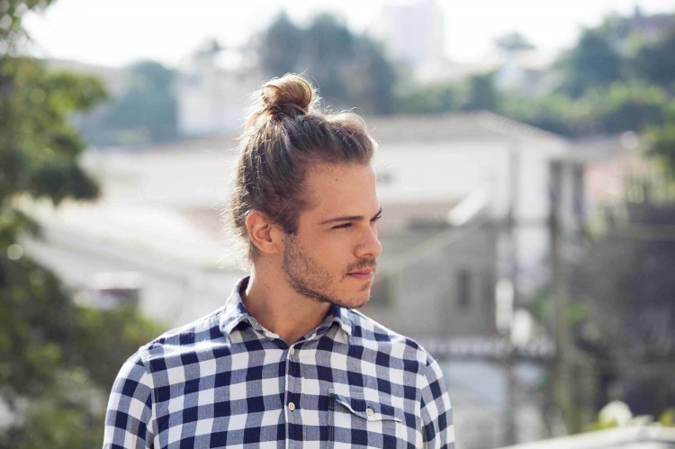 Homme suivant la tendance et portant un chignon haut sur la tête