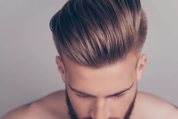 Homme blond avec des cheveux raides et une coupe Social Slicked Back tirée en arrière